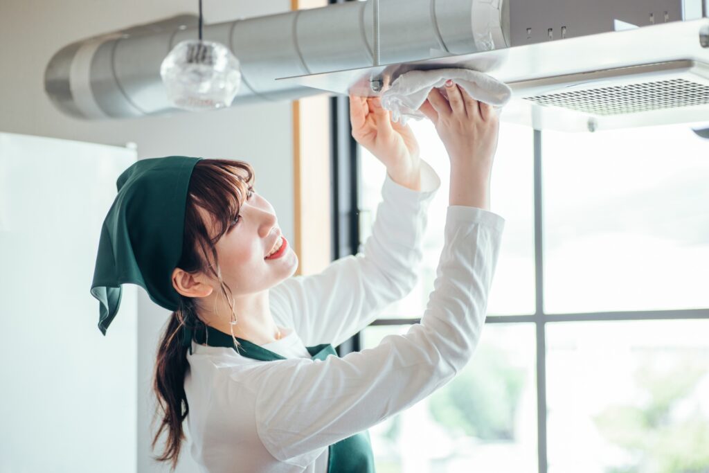 ハウスクリーニングで換気扇を掃除している女性の画像
